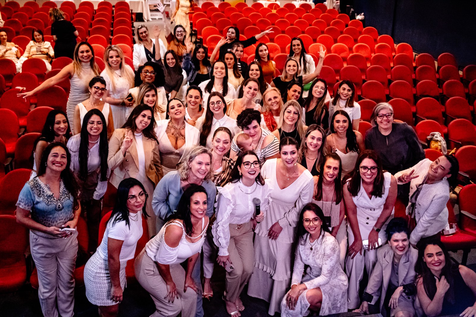 Plateia de profissionais reunidas em auditório após um evento presencial